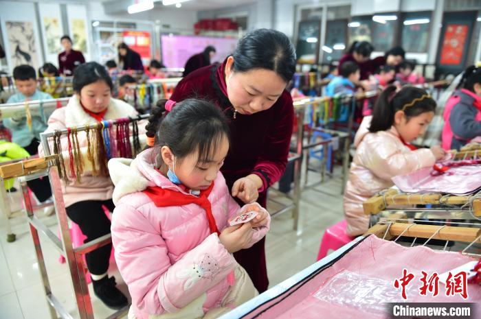 江西省級非遺豫章繡傳承人手把手指導小學生繡制2022年北京冬奧會吉祥物“冰墩墩”形象?！∮髟屏?攝