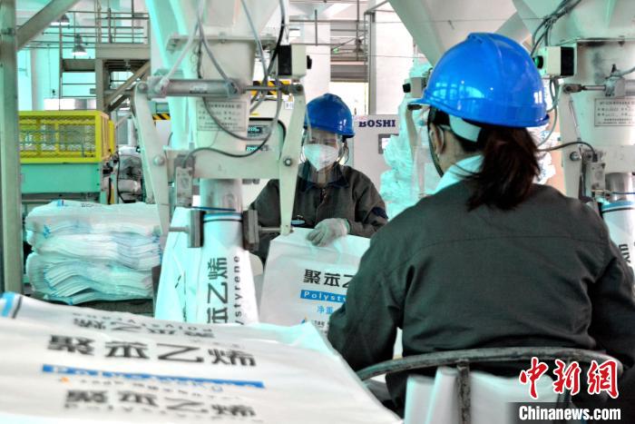 工人在生產(chǎn)線上包裝聚苯乙烯產(chǎn)品?！×趾霔v 攝