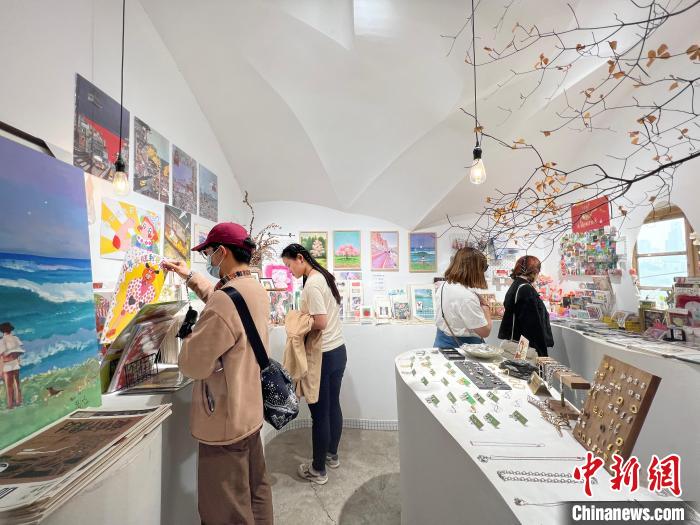 圖為藝術(shù)品商店內(nèi)，顧客挑選插畫作品。　鐘旖 攝