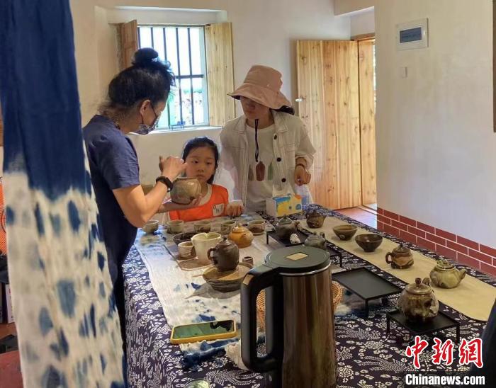 圖為：游客正在咨詢臺灣柴燒作品?！∪~秋云 攝