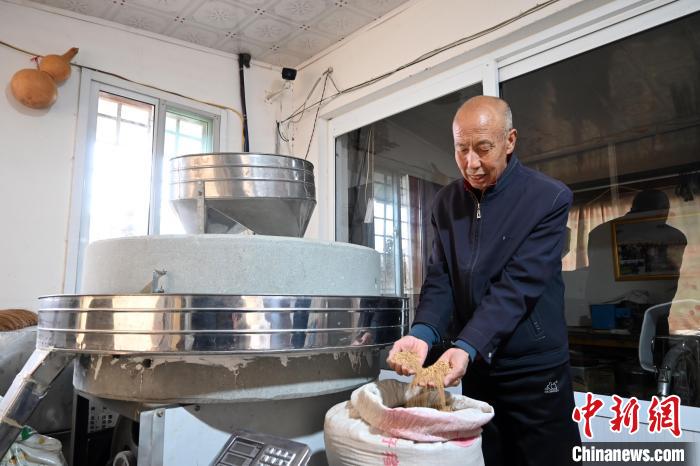 李家莊村民谷文朝重拾父輩的手藝，做起石磨面粉的營生?！〉杂鸺?攝