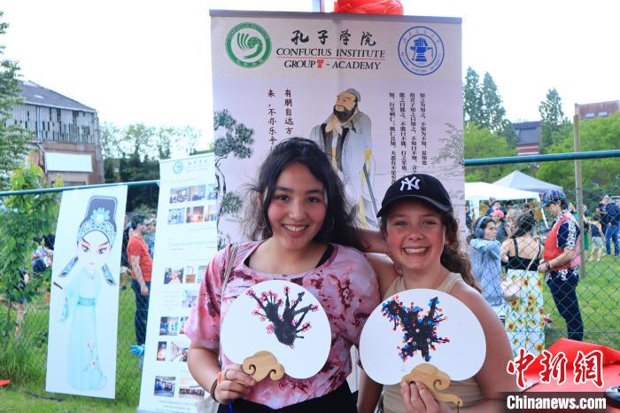 孩子們展示自己的吹墨畫團(tuán)扇作品?！◆斻肟鬃訉W(xué)院供圖