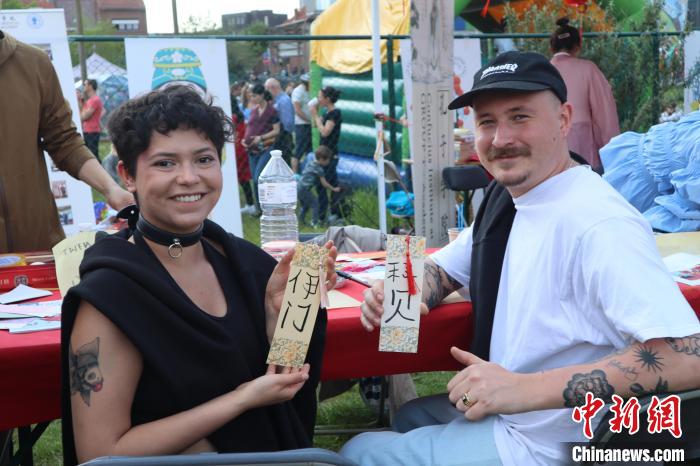 當(dāng)?shù)孛癖娫跐h字體驗工作坊展示自己手寫的中文名書簽?！◆斻肟鬃訉W(xué)院供圖