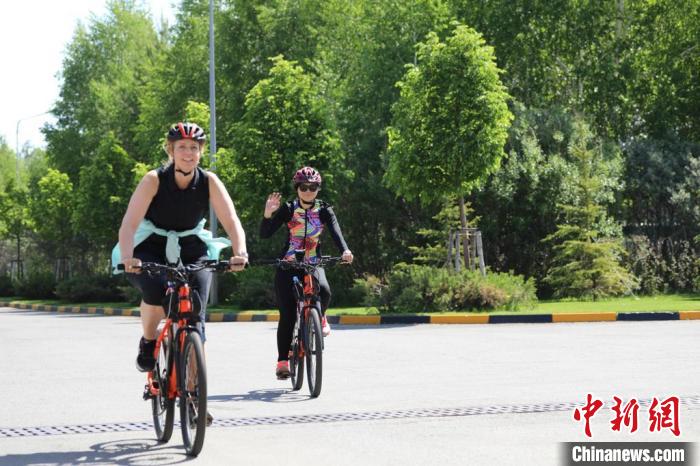 亞信副秘書長(zhǎng)遲方(右一)與聯(lián)合國(guó)駐哈協(xié)調(diào)員在騎行活動(dòng)中?！喰琶貢幑﹫D