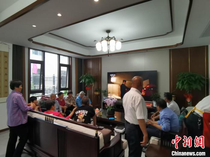 親友們集中在費(fèi)俊龍家中觀看返程的視頻?！＄娚?攝