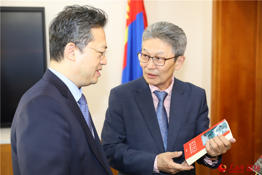 其米德策耶（右一）向李峙介紹翻譯成果。人民網(wǎng)記者 霍文攝