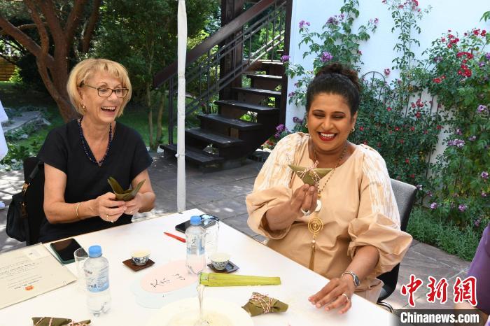 圖為嘉賓展示包粽子成果?！“亓种袊幕行墓﹫D。