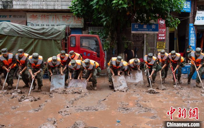 7月4日，萬州區(qū)五橋街道，武警官兵清理街道上的淤泥。　冉孟軍 攝