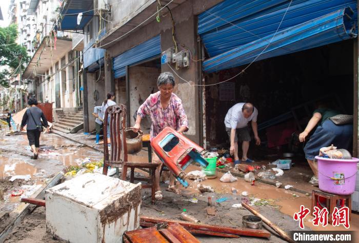 7月4日，萬州區(qū)五橋街道，洪水退去后，居民搶救生活物資?！∪矫宪?攝