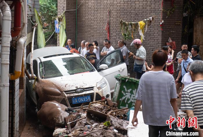 7月4日，萬州區(qū)五橋街道，居民救援受困的私家車。　冉孟軍 攝
