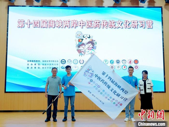 共青團(tuán)福建省委副書記吳雪(右一)、福建中醫(yī)藥大學(xué)黨委副書記林羽(左一)為兩岸學(xué)生代表頒授營旗?！≡S燁婷 攝