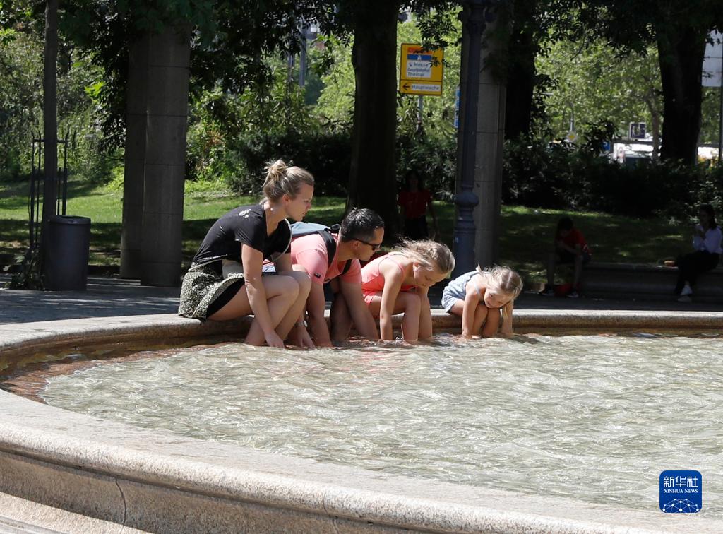 7月8日，人們在德國法蘭克福的一處噴泉玩水。近日，德國法蘭克福逐漸迎來暑熱天氣。新華社記者 張帆 攝