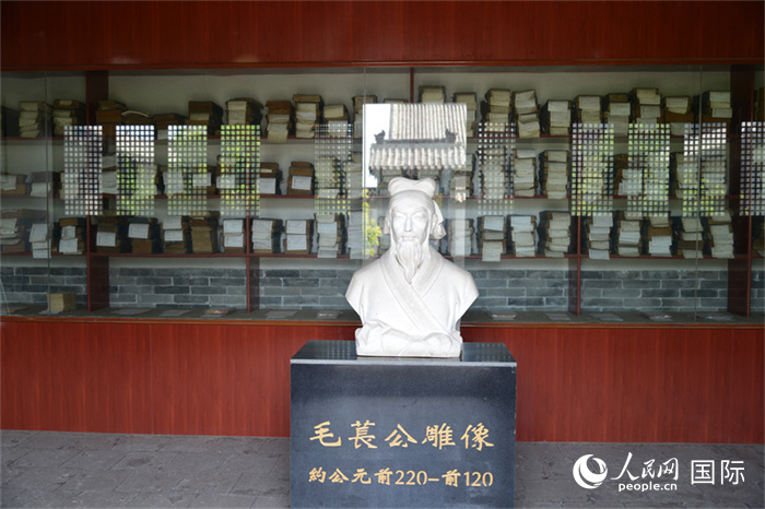 河間詩(shī)經(jīng)齋毛萇雕像。雕像后書櫥中陳列的是歷代各版本《詩(shī)經(jīng)》及譯本。 人民網(wǎng) 趙昭攝