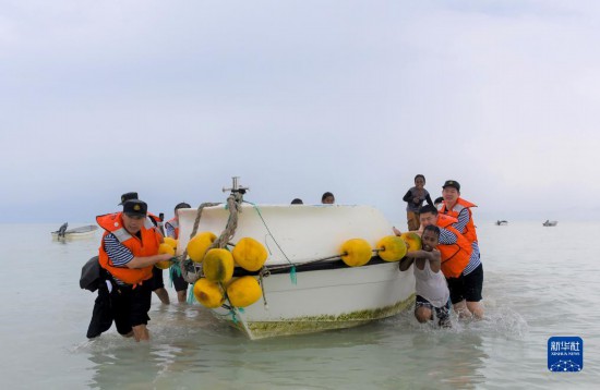 7月21日，中國海軍“和平方舟”號醫(yī)院船醫(yī)護人員涉水登島，前往基里巴斯一診療點。新華社記者 黎云 攝
