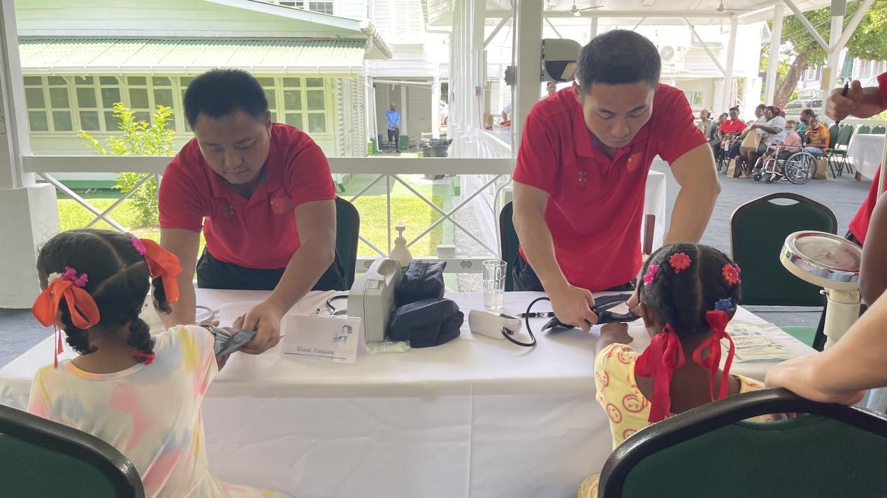 醫(yī)療隊(duì)員為福利院兒童進(jìn)行檢查。第18期援圭亞那醫(yī)療隊(duì)供圖