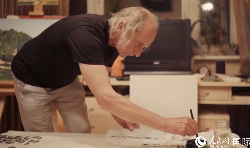 伊戈爾·布爾東諾夫在畫作上題詞。人民網(wǎng)記者 馬天翼攝