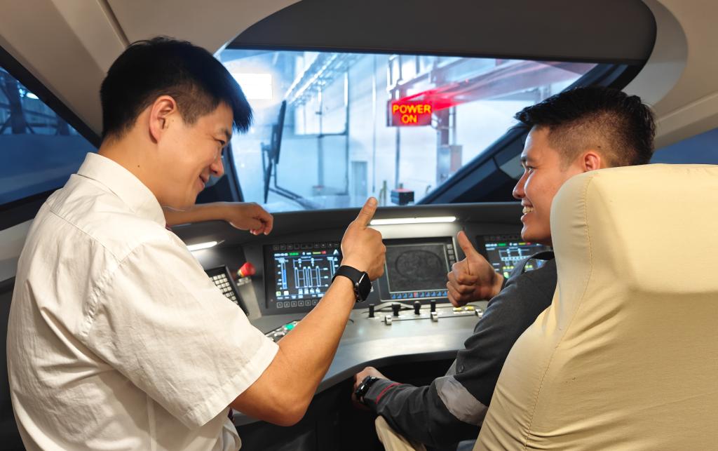 8月25日，在印度尼西亞萬(wàn)隆的雅萬(wàn)高鐵德卡魯爾動(dòng)車(chē)所內(nèi)，中國(guó)師傅穆振（左）在向印尼火車(chē)司機(jī)塞蒂亞萬(wàn)講解動(dòng)車(chē)組出庫(kù)前的上電作業(yè)。