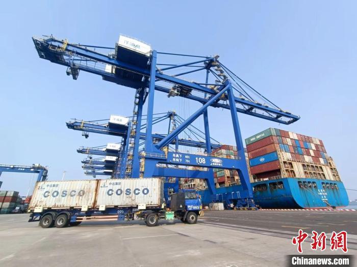 圖為海南洋浦國(guó)際集裝箱碼頭，卡車(chē)將集裝箱從后方堆場(chǎng)運(yùn)往碼頭裝卸區(qū)?！?jiān)潞?攝