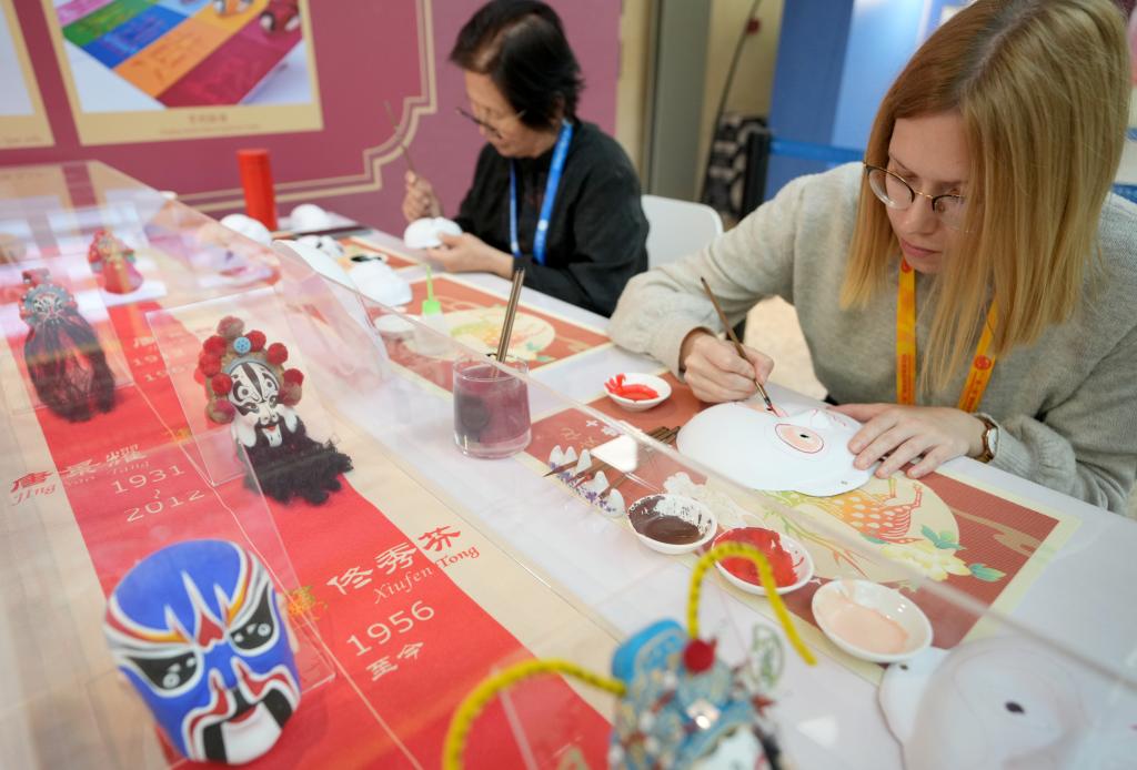 10月16日，在第三屆“一帶一路”國(guó)際合作高峰論壇新聞中心，來(lái)自比利時(shí)的記者（右）體驗(yàn)畫京劇臉譜。新華社記者 王毓國(guó) 攝