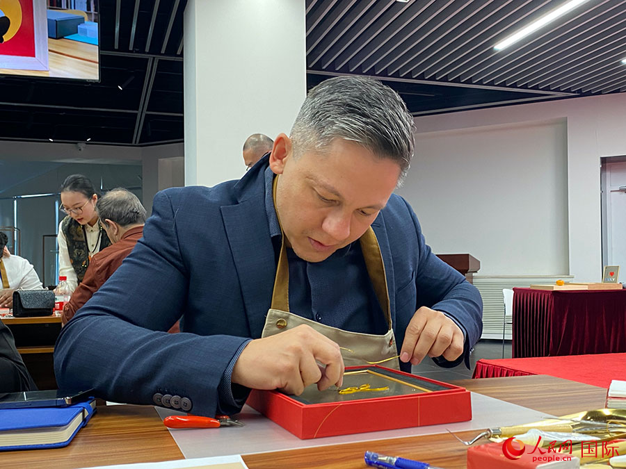 2023“一帶一路”媒體合作論壇聯(lián)合采訪團團員，親身體驗景泰藍工藝。人民網(wǎng)記者 于洋攝