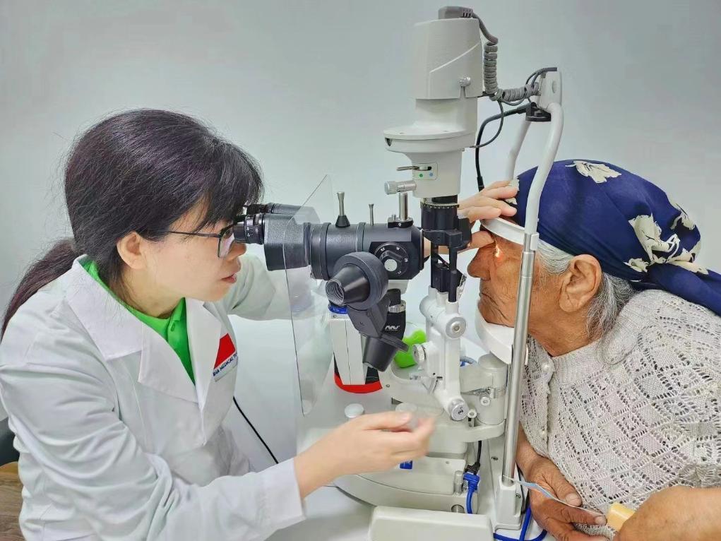 北京大學(xué)人民醫(yī)院眼科醫(yī)生鮑永珍正在為中亞白內(nèi)障患者進(jìn)行眼部檢查。（北京大學(xué)人民醫(yī)院供圖）