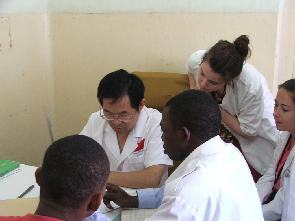 2011年7月22日，在坦桑尼亞桑給巴爾納茲莫加醫(yī)院外科門診，中國第24批援桑給巴爾醫(yī)療隊隊長盧建林為當(dāng)?shù)鼗颊咴\治并帶教實(shí)習(xí)生。新華社發(fā)（國家衛(wèi)生健康委供圖）