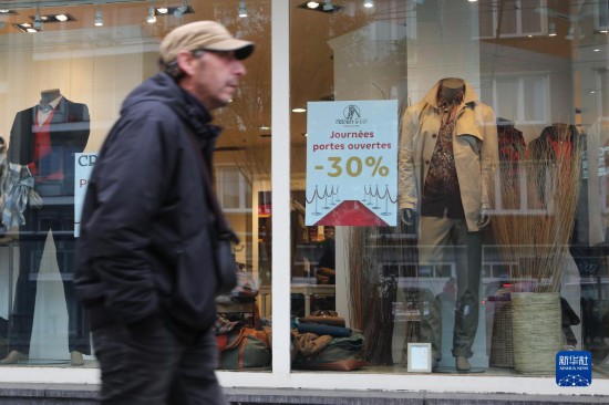   10月31日，一名男子從比利時(shí)布魯塞爾一家貼有打折信息的店鋪前走過(guò)。新華社記者 趙丁喆 攝