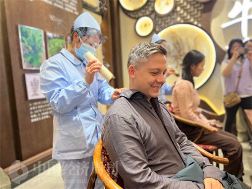   （外媒記者體驗艾灸。中國經(jīng)濟周刊記者 郭志強 攝）
