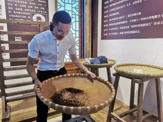 2023“一帶一路”媒體合作論壇聯(lián)合采訪團(tuán)團(tuán)員在非遺文化展示館體驗(yàn)中藥炮制技藝。（本報(bào)記者 黃超攝）