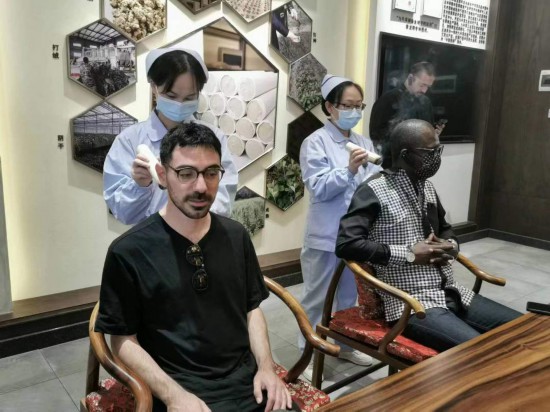 2023“一帶一路”媒體合作論壇聯(lián)合采訪團(tuán)團(tuán)員在九牛草展示館體驗(yàn)艾灸。（本報(bào)記者 黃超攝）