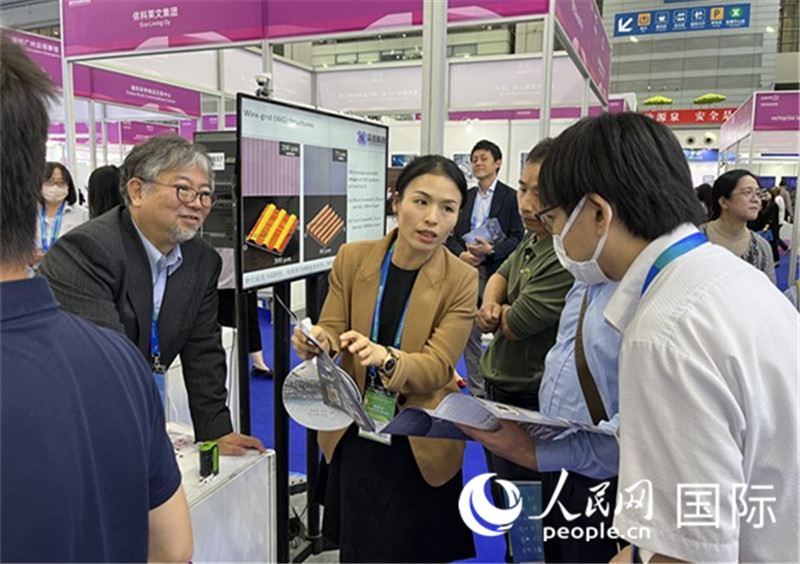 工作人員向參觀者介紹超級(jí)噴墨技術(shù)。（人民網(wǎng)記者 陳思攝）