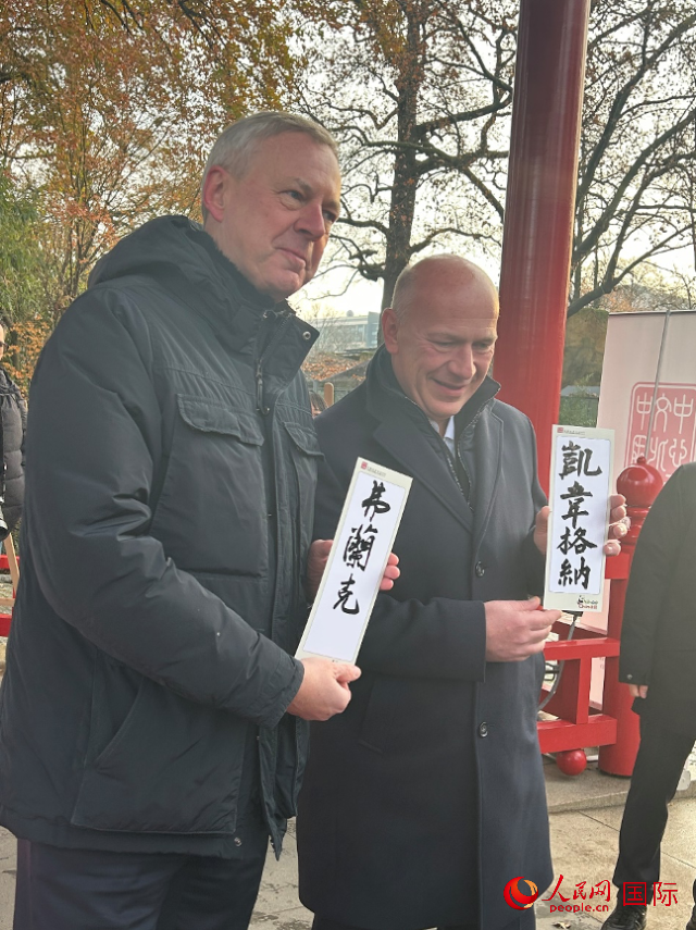 柏林市長韋格納（右）、動物園監(jiān)事會主席布魯克曼（左）手持中國文化中心工作人員現(xiàn)場手書的中文名字。人民網(wǎng)記者 徐馨攝