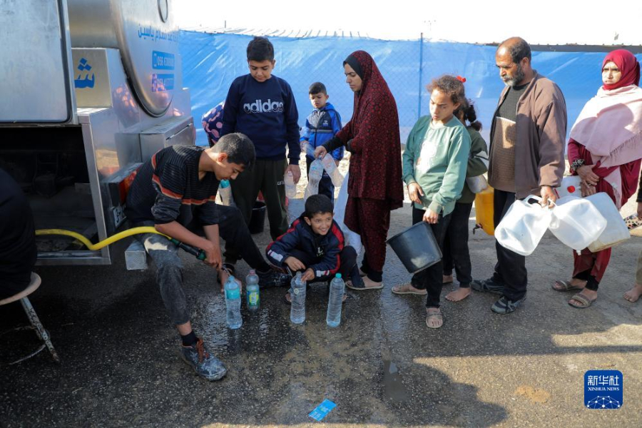 12月8日，在加沙地帶南部城市拉法一處臨時(shí)營(yíng)地內(nèi)，人們排隊(duì)打水。新華社發(fā)（里澤克·阿卜杜勒賈瓦德 攝）