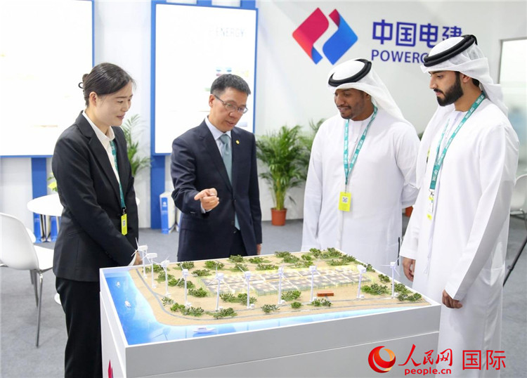 訪客在中國電建展臺參觀風(fēng)電項目沙盤。人民網(wǎng) 塔里克·易卜拉欣攝