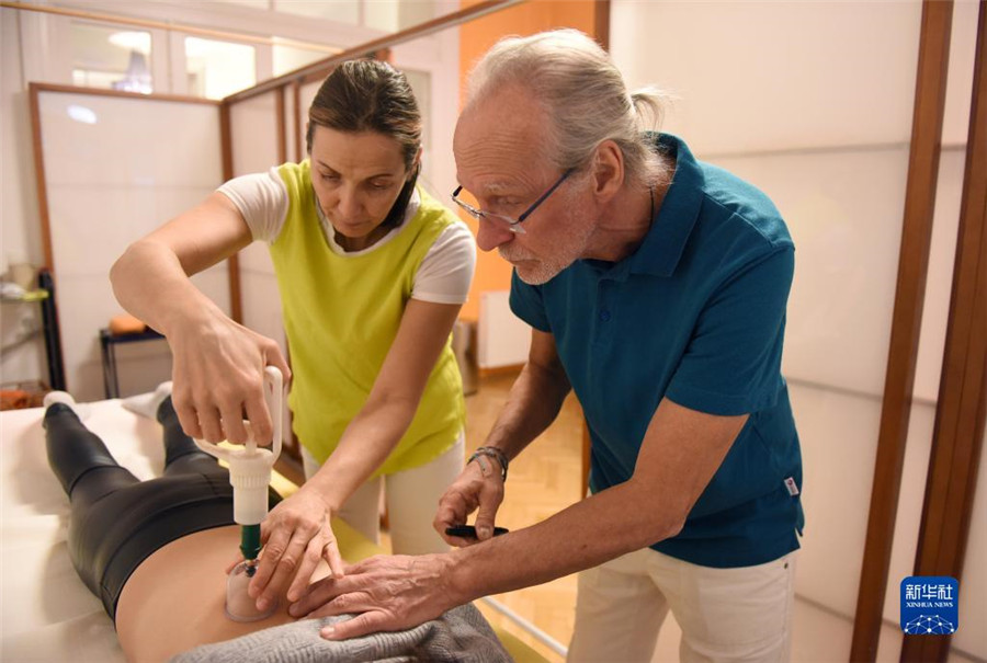 12月12日，在奧地利維也納，科格勒醫(yī)生（右）和助手在為病人進(jìn)行拔罐治療。新華社記者 賀燦鈴 攝