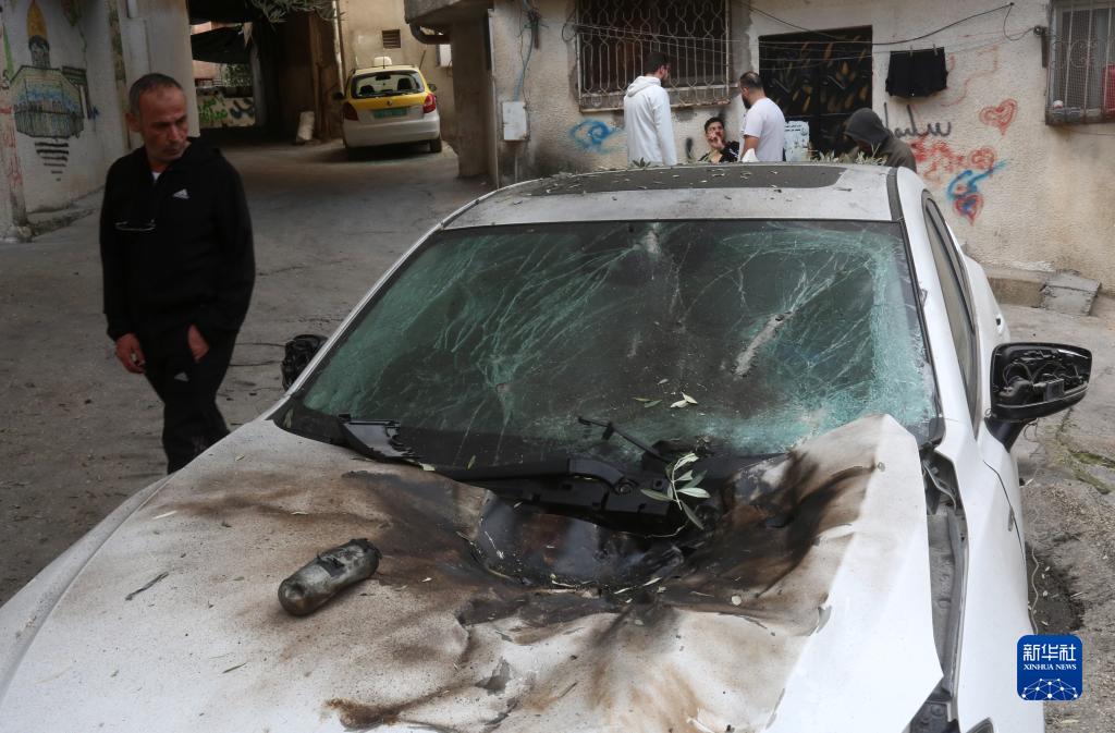 12月17日，在約旦河西岸城市圖勒凱爾姆附近的一處難民營(yíng)，人們查看在沖突中損毀的車輛。新華社發(fā)（尼達(dá)爾·艾仕塔耶?dāng)z）
