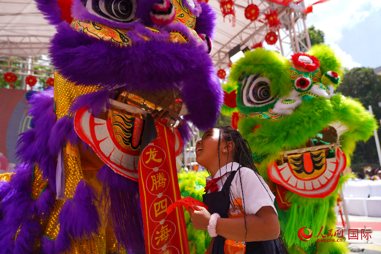 小朋友與舞獅表演者互動。人民網(wǎng)記者 黃煒鑫攝