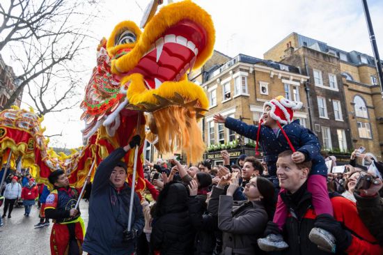 2月11日，人們在英國倫敦的新春巡游活動中觀看舞龍表演。新華社發(fā)（史蒂芬·程攝）