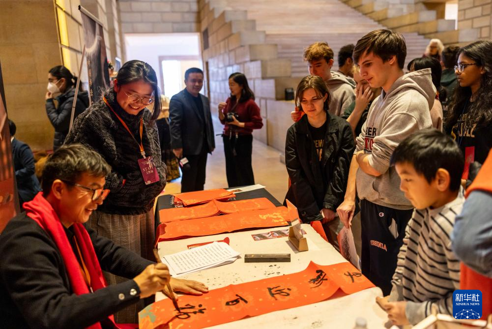 2月11日，書法家在美國費城藝術博物館舉行的龍年迎新春活動上為參觀者書寫對聯。新華社發(fā)（周煥新攝）