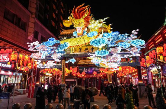 2月11日，游客在沈陽(yáng)中街游覽。春節(jié)期間，各地?zé)艋痂病⒒饦?shù)銀花，呈現(xiàn)出一幕幕流光溢彩的視覺(jué)盛宴。（新華社記者潘昱龍攝）