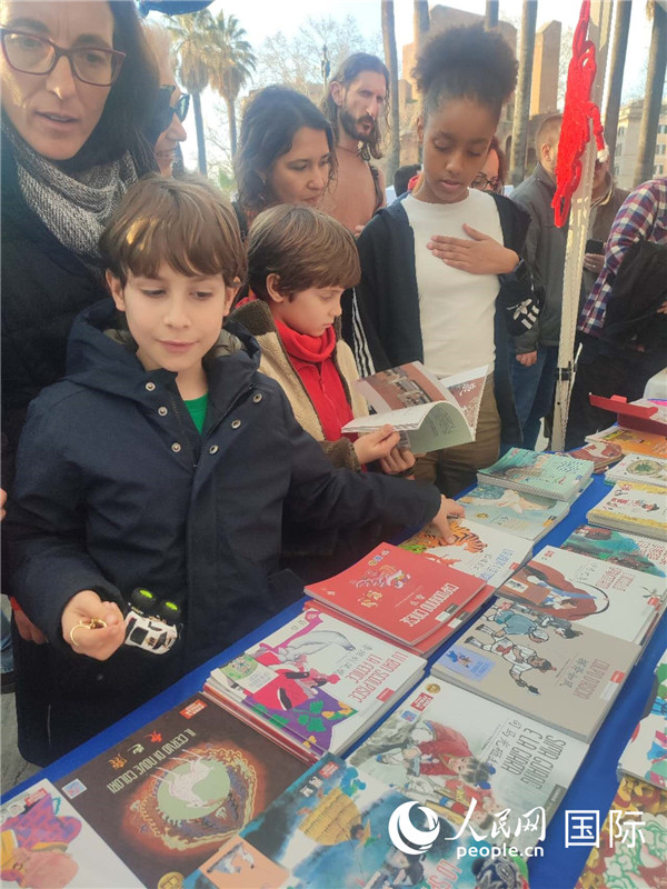 印刷精美的中國(guó)傳統(tǒng)文化叢書(shū)吸引了小游客的注意。人民網(wǎng)記者鄭彬攝