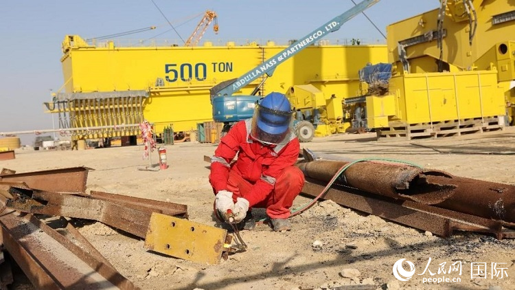 工人正在龍門吊吊裝現場切割金屬件。人民網記者管克江攝