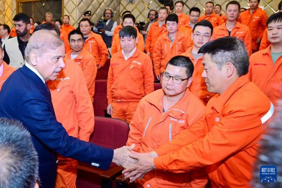 4月1日，在巴基斯坦西北部開伯爾-普什圖省達蘇，巴基斯坦總理夏巴茲（左）同達蘇水電站項目中方員工握手。新華社發(fā)（巴基斯坦新聞與廣播部下轄媒體信息部門供圖）