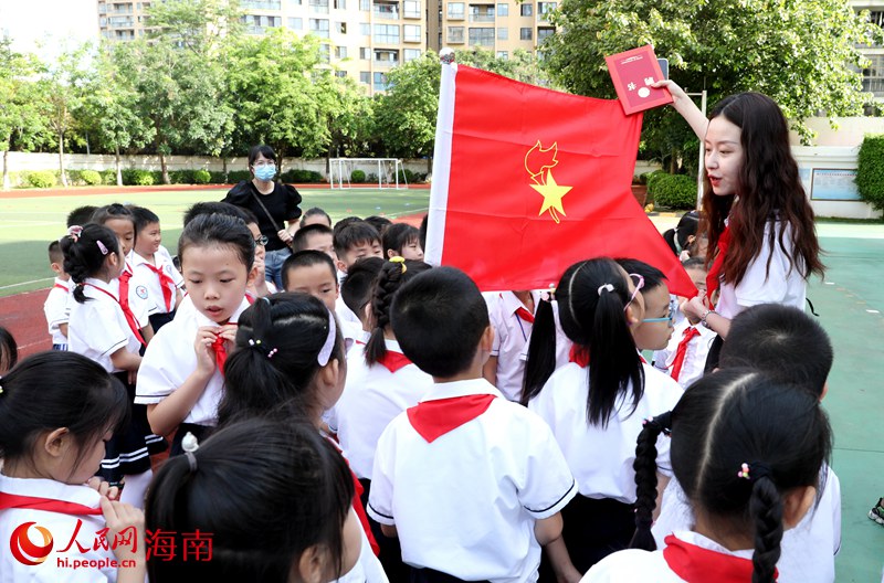 老師向少先隊(duì)員展示隊(duì)旗。人民網(wǎng) 符武平攝