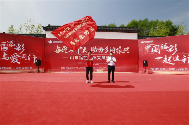 為媒體采風(fēng)團授旗。 山東省福彩供圖