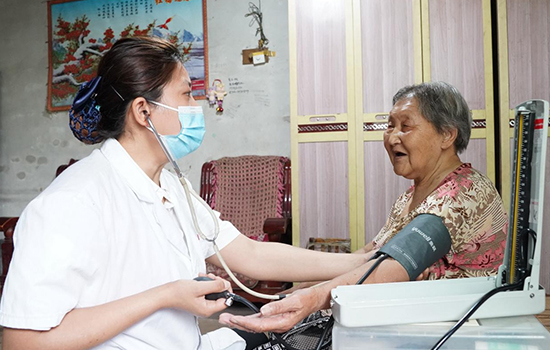 護(hù)理團(tuán)隊(duì)醫(yī)生為老人測(cè)量血壓。 陳佳兵攝