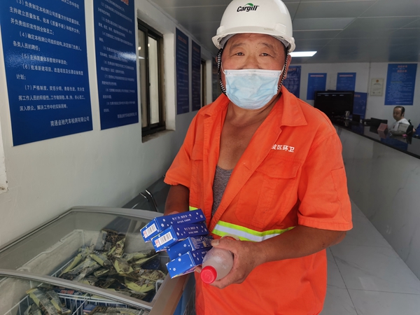 1環(huán)衛(wèi)工倪建宏小憩后，為還同事帶去冷飲。人民網(wǎng)記者王繼亮攝