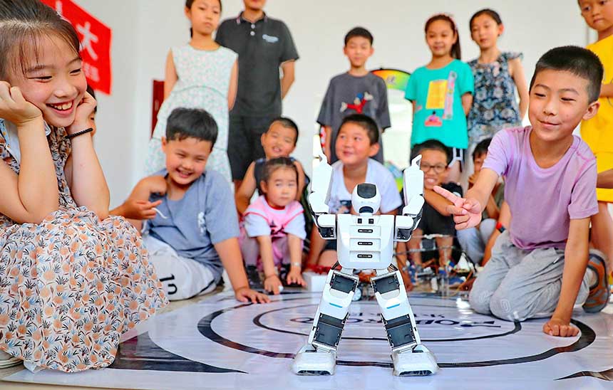 2022年7月19日，河北省秦皇島市海港區(qū)白塔嶺街道秦皇半島第二社區(qū)內(nèi)，小朋友正在觀看“機(jī)器人跳舞”。 曹建雄攝