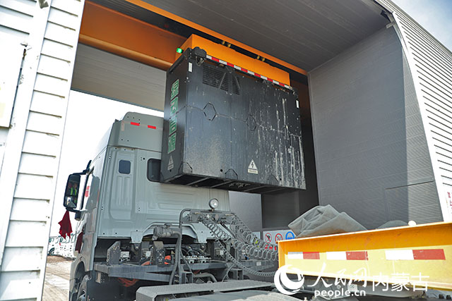 萬利新能源數(shù)字陸港里，正在充換電站進行換電的重卡。人民網(wǎng)記者 趙夢月攝