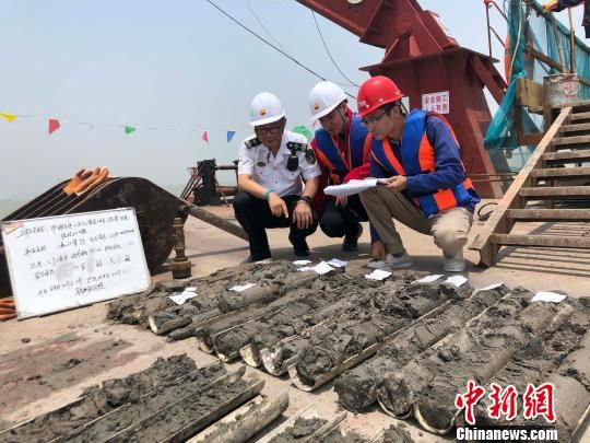 圖為勘察設(shè)計(jì)人員與海事局工作人員查看巖芯情況。　魏震 攝